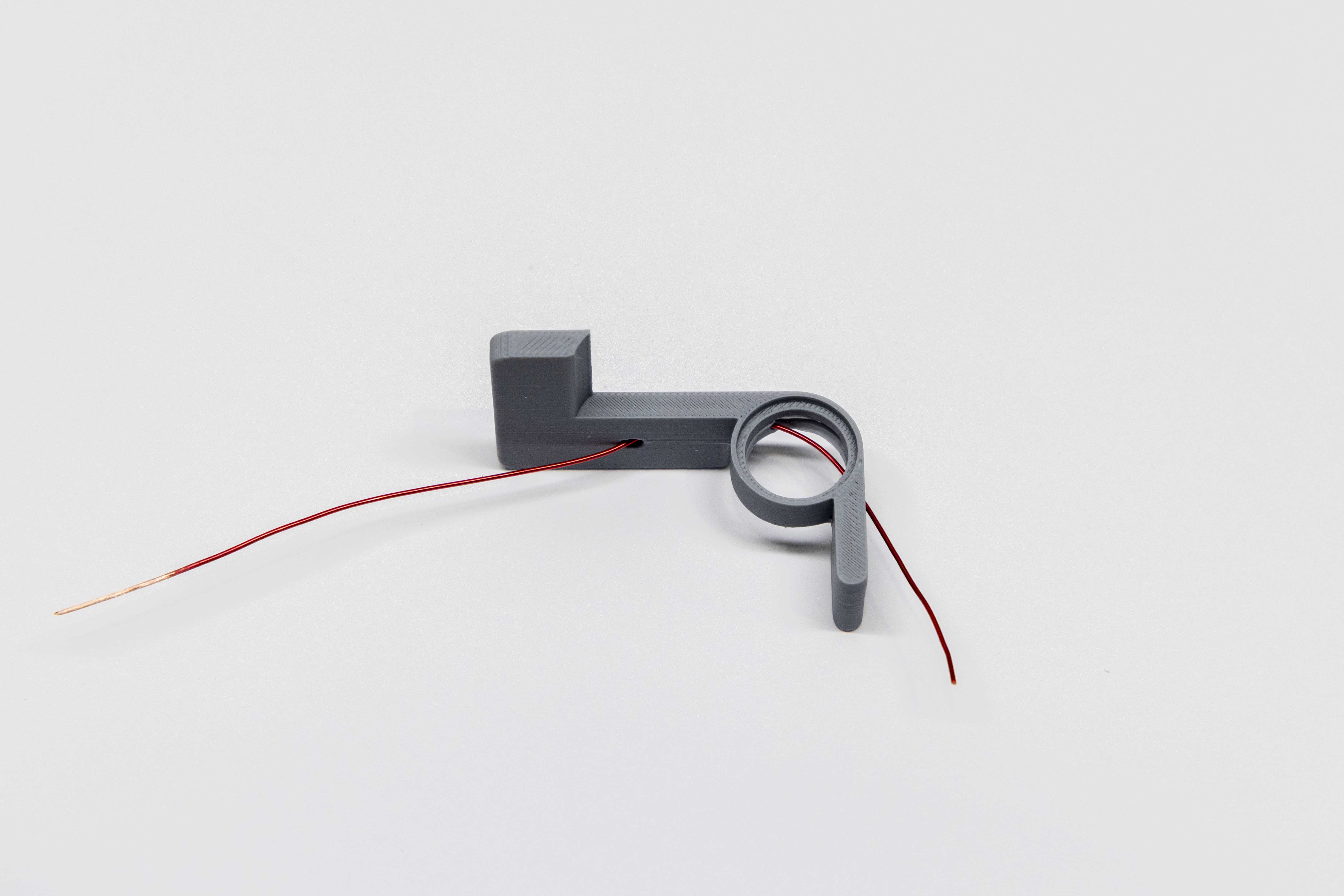 Magnet wire being threaded through paddle arm