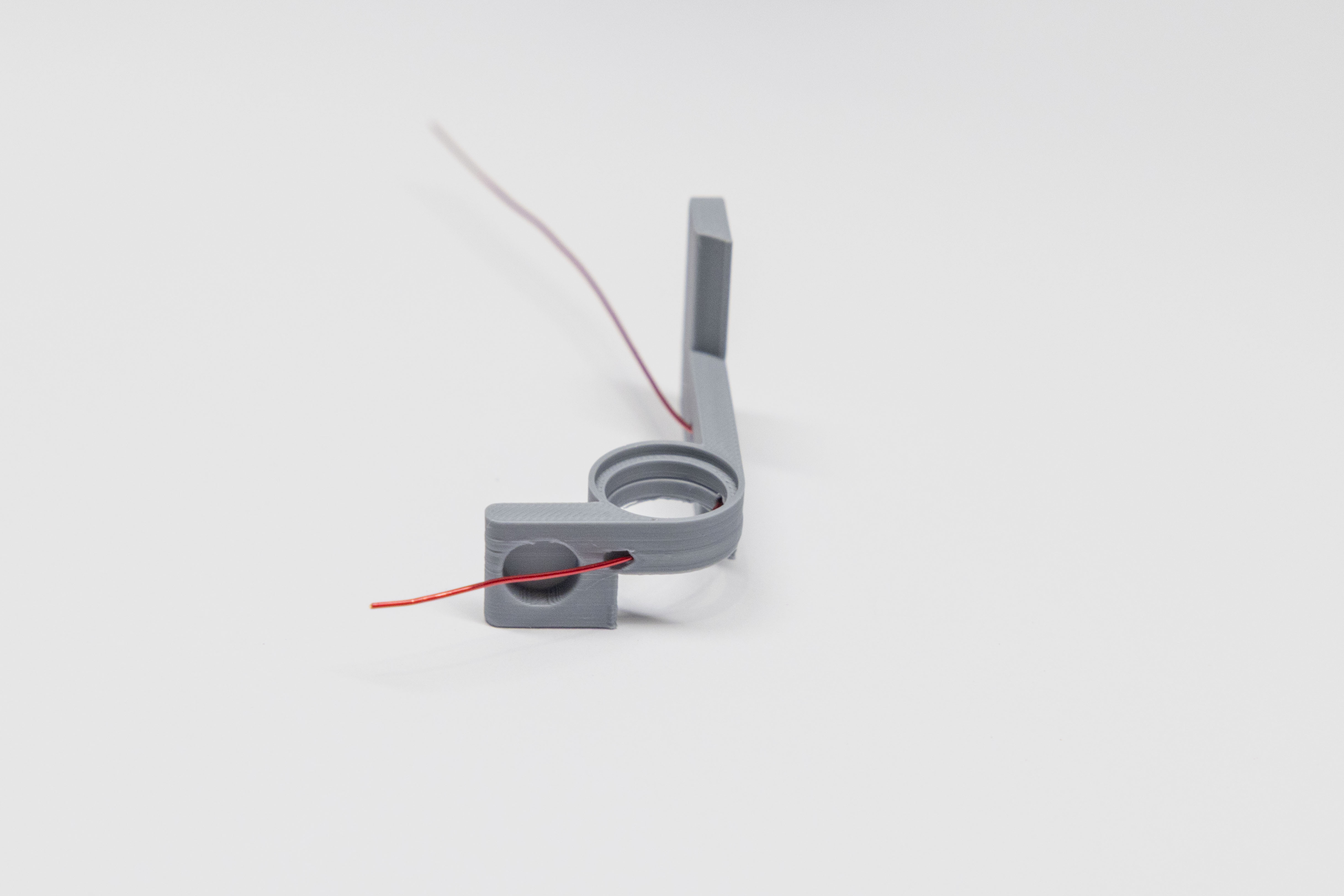 Wire fed through second hole near bearing ring